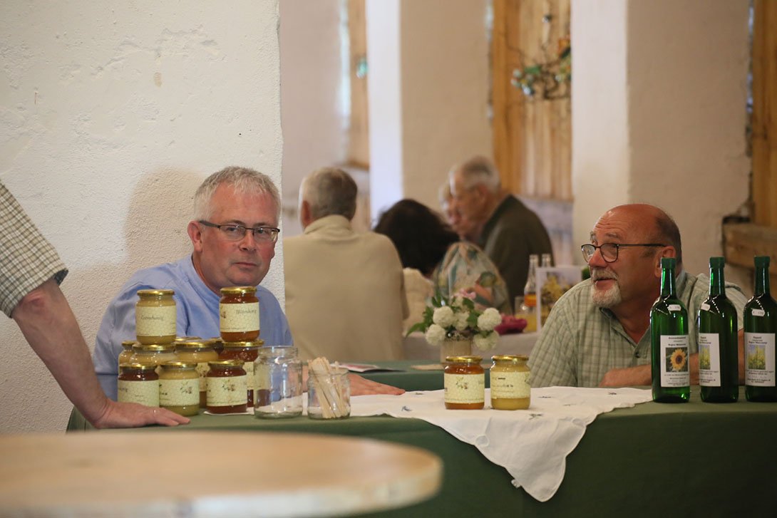 Gespräch über Honig, Säfte und Natur: Josef Benedikt und Johann Muth mit seinen Produkten. Foto © R. Raberger - Blütenfest 14.5.2022